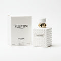 Valentino perfume bottle and packaging on a marble surface with a dark background